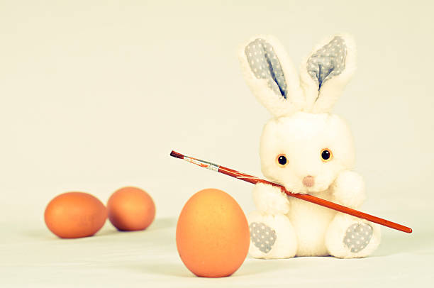 istock Toy rabbit with eggs and painting brush 469102384