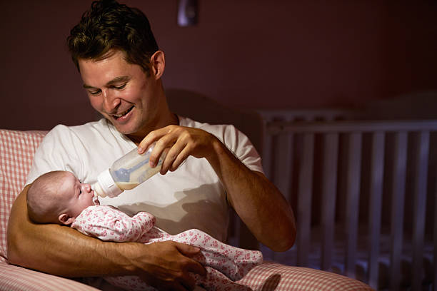 istock Father Feeding Baby With Bottle In Nursery 469105238