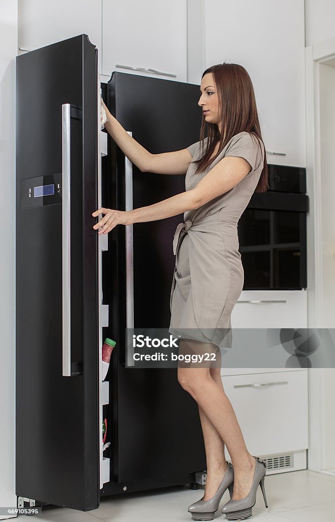 Young woman in the kitchen Reaching Stock Photo