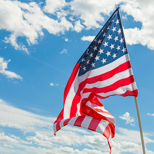 istock USA flag with clouds on background - outdoors shoot 469105886