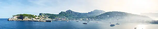 Panorama image of Port de Sóller on the island Mallorca in Spain. Early morning shot with mist rising from the sea.