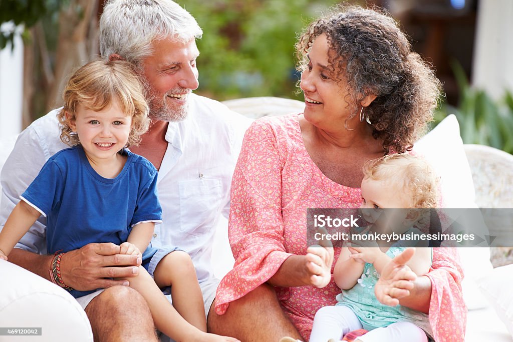 Grandparents At Home Sitting Outdoors With Grandchildren 12-23 Months Stock Photo