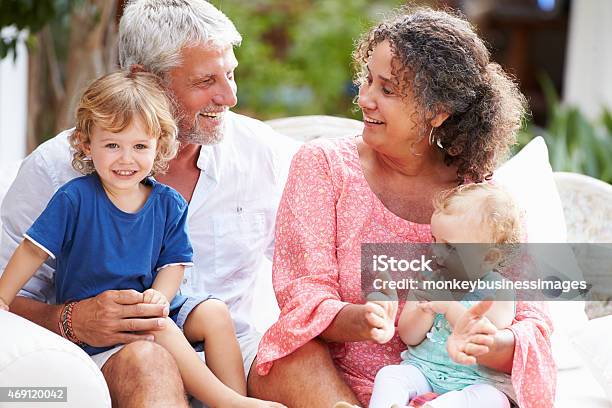 Grandparents At Home Sitting Outdoors With Grandchildren Stock Photo - Download Image Now