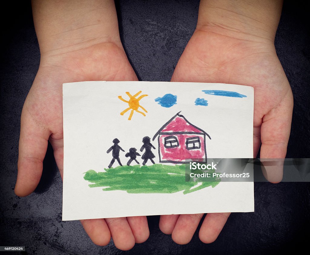 Child holds a drawn house with family Child holds a drawn house with family. Close up. Vignette. Family Stock Photo