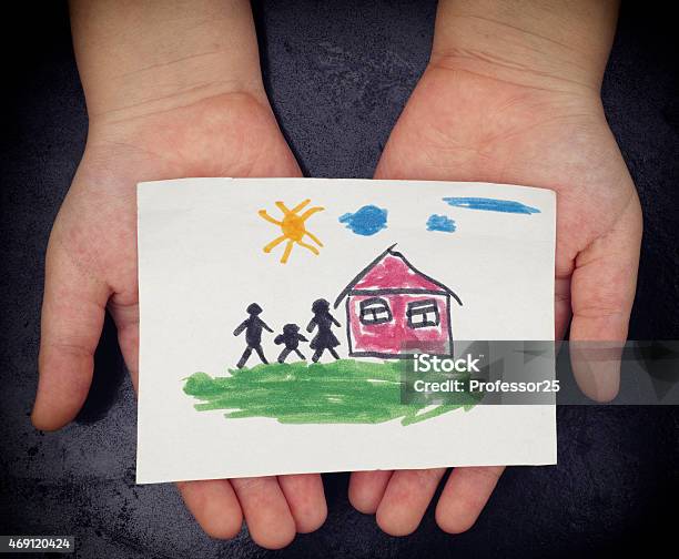 Child Holds A Drawn House With Family Stock Photo - Download Image Now - Family, Child, Child's Drawing