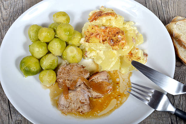 meat platter with gratin potatoes and Brussel sprouts on the wood table