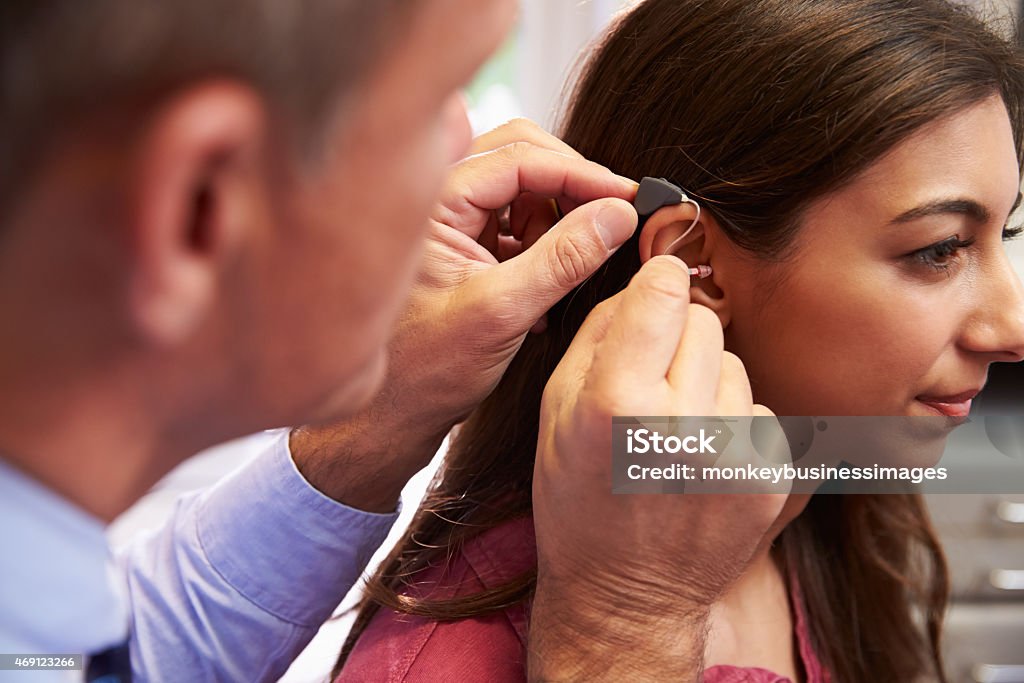 Taglio femminile medico paziente con Apparecchio acustico - Foto stock royalty-free di Apparecchio acustico