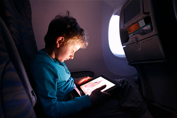 istock Little boy playing with tablet on the airplane 469128354