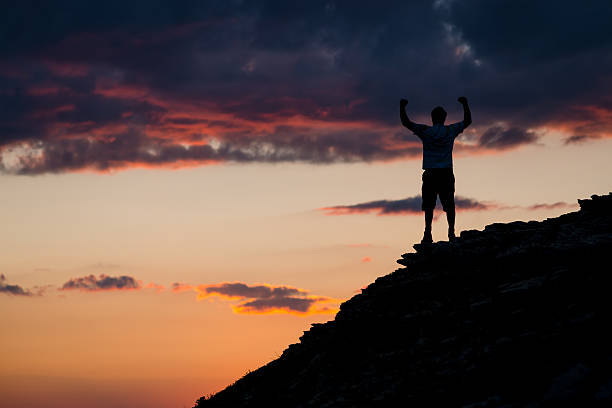 istock Man Raises Arms in Excited Elation atop Mountain Summit 469138483