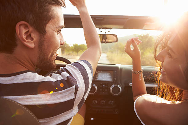 jovem casal ao longo da estrada secundária em condução aberto carro top - image singing fun vacations imagens e fotografias de stock