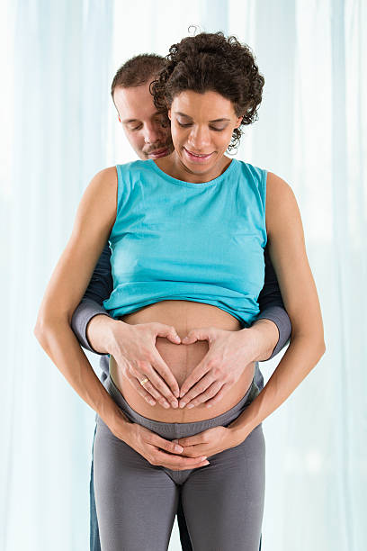 istock Pregnant couple making heart shape with hands 469144101