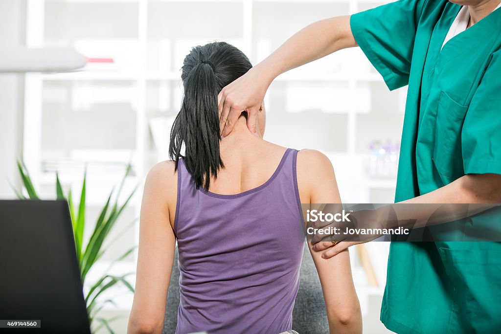 Chiropractor stretches female patient neck muscles Physical Therapy Stock Photo