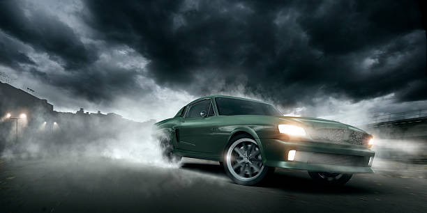Green Muscle Car Burnout Green muscle car doing a burnout moving at speed at night on urban industrial road under dramatic stormy sky. Intentional heat haze from engine. sports car stock pictures, royalty-free photos & images