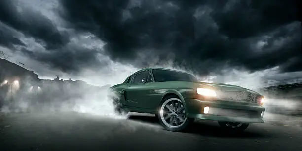 Green muscle car doing a burnout moving at speed at night on urban industrial road under dramatic stormy sky. Intentional heat haze from engine.