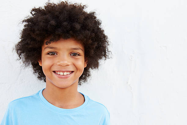 Smiling Young Boy Standing Outdoors Against White Wall Smiling Young Boy Standing Outdoors Against White Wall 8 9 years stock pictures, royalty-free photos & images