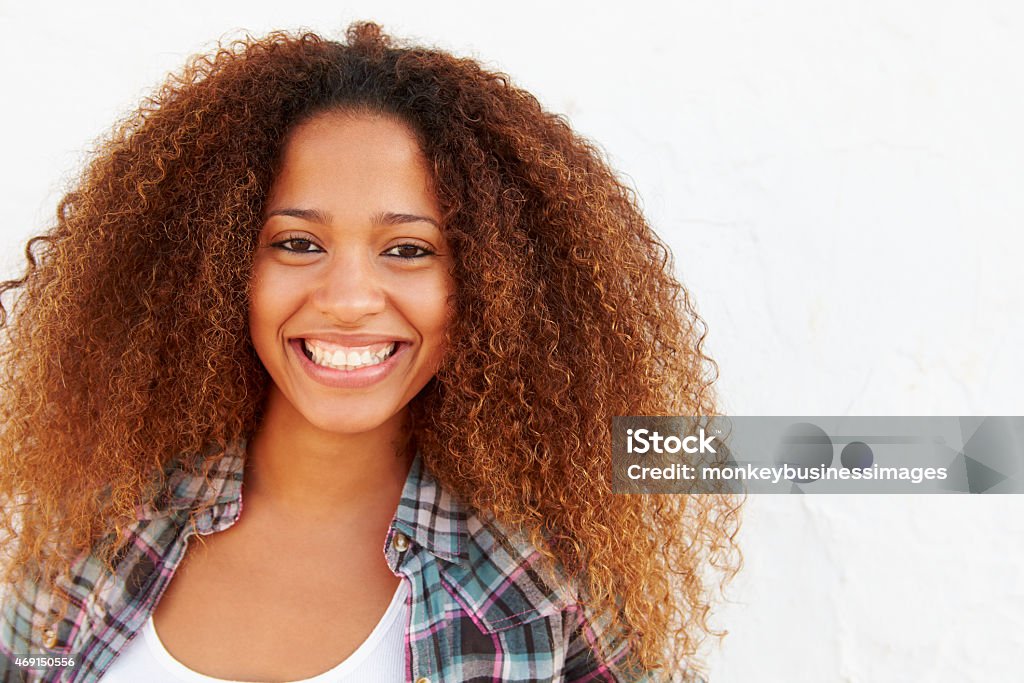 Portrait Of Woman Standing Outdoors Against White Wall Portrait Of Woman Standing Outdoors Against White Wall,  Smiling To Camera 20-29 Years Stock Photo