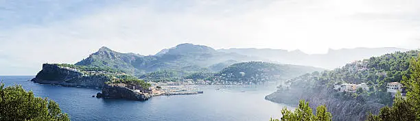 Panorama image of the bay of Port de Sóller on the island Mallorca in Spain. Early morning shot with mist rising from the sea.