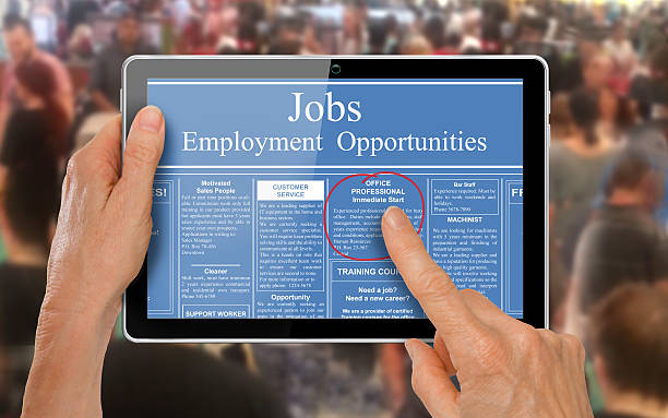 Reading online job ads on a computer tablet - stock photo