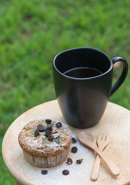 muffin de mirtilo com xícara de café sobre fundo verde - muffin blueberry muffin healthy eating bran muffin - fotografias e filmes do acervo