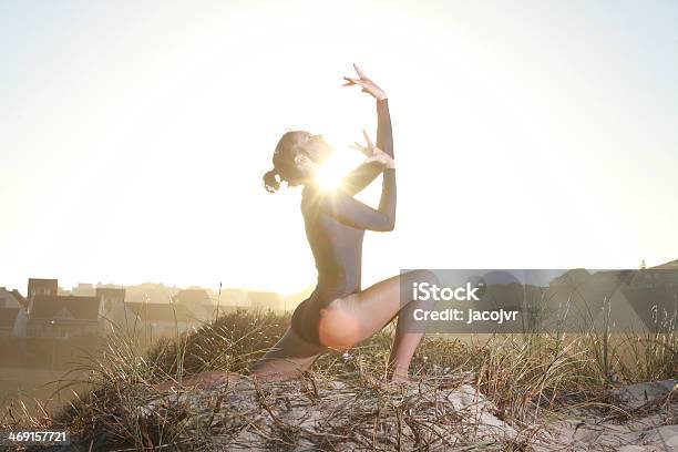 Gymnast Worshipping With Sun Behind Her Stock Photo - Download Image Now - Adult, Angel, Athlete