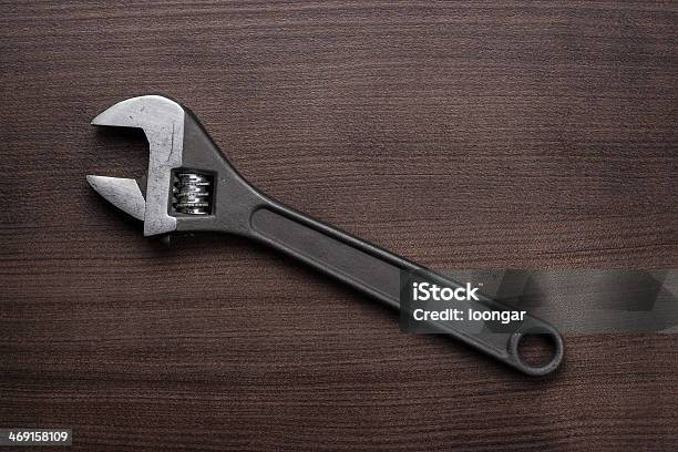 Adjustable Wrench On The Wooden Table Stock Photo - Download Image Now - Adjustable Wrench, Brown, Table