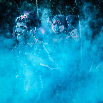 Blue image, due to the color pigments thrown around by a group of young Indian people celebrating the Holi Festival in Jaipur, India.