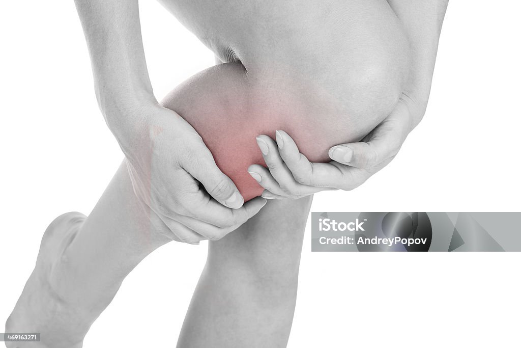 A woman holding her leg from pain Close up of woman leg injury isolated on white background Adult Stock Photo