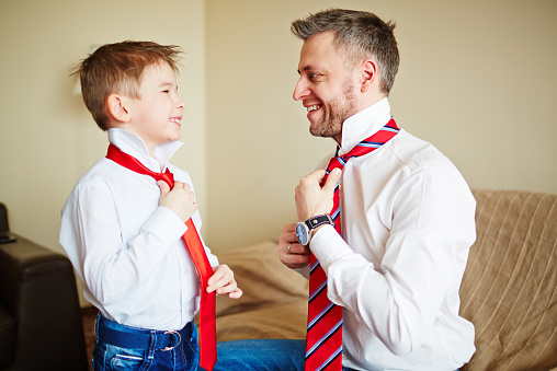 Father and son knotting ties
