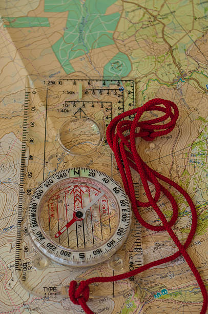 kompass auf einer karte - orienteering planning mountain climbing compass stock-fotos und bilder