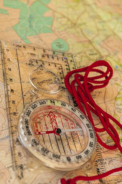 kompass auf einer karte - orienteering planning mountain climbing compass stock-fotos und bilder