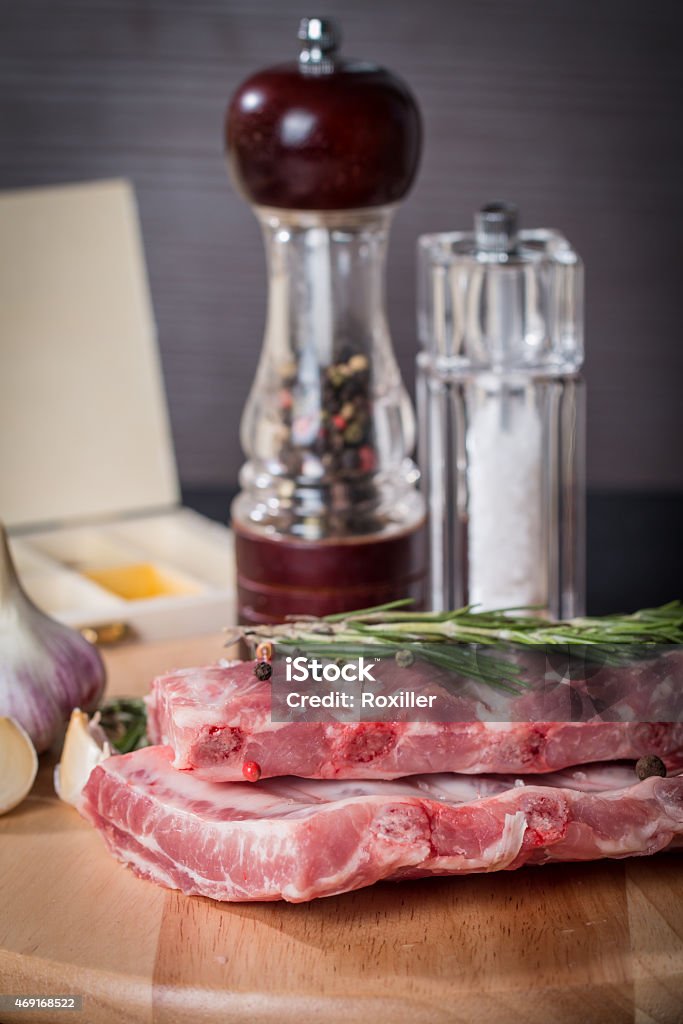 Fresh pork ribs, meat  with garlic allspice Fresh pork ribs, meat marinated and prepared for roast with garlic allspice on wooden background 2015 Stock Photo