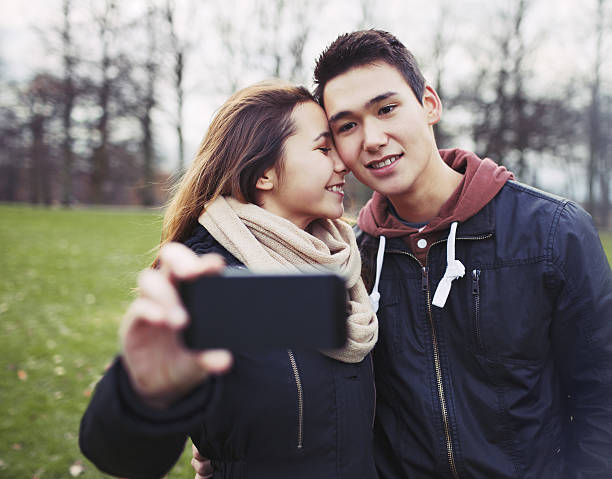 istock Affectionate young couple taking pictures using a smart phone 469174341