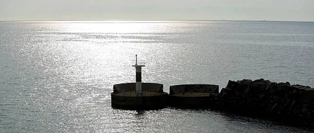 Sunset over the baltic sea whit a stone pier in the foreground.JH