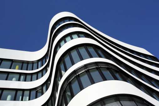 office building exterior close-up with curvy lines and wave pattern on a clear sunny day