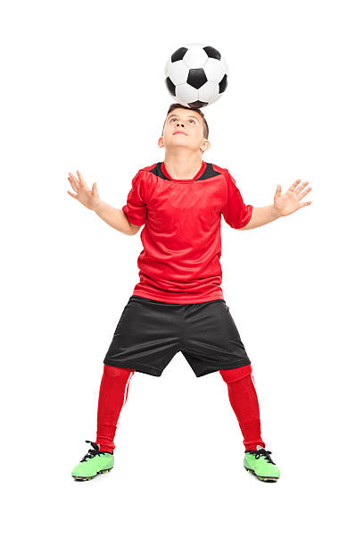 joueur de football junior joggling avec un ballon - soccer child indoors little boys photos et images de collection
