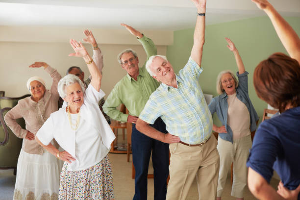 Some gentle stretching of their muscles Daily stretching exercise routine for the elderly at an old age home exercise class stock pictures, royalty-free photos & images