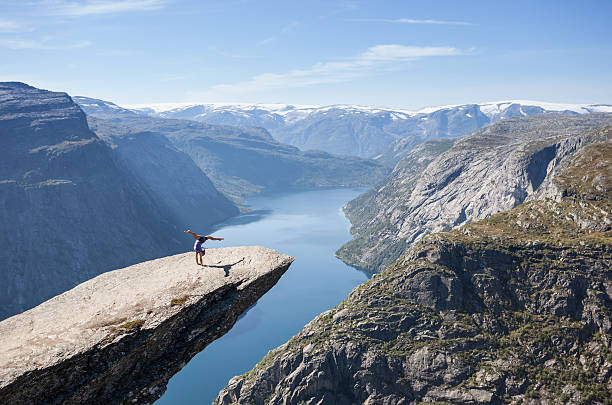 female gymnast doing a handstand on trolltunga rock in norway stock photo