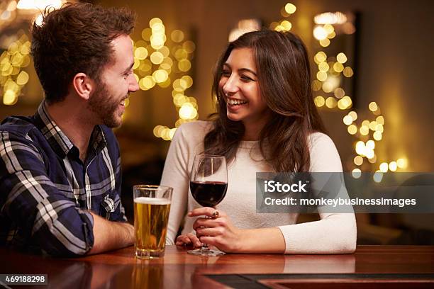 Couple Enjoying Evening Drinks In Bar Stock Photo - Download Image Now - Couple - Relationship, Dating, Bar - Drink Establishment