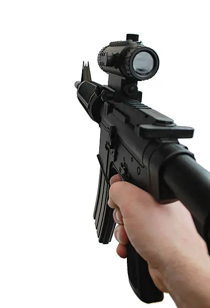 Photo of a hand aiming a customized M16 automatic rifle with scope from a First Person perspective. Isolated on a white background.