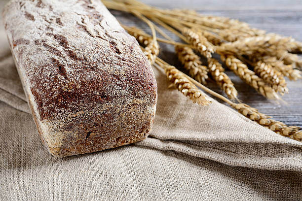 istock Fresh Loaf of Bread with wheat spikelets on a sacking 469191638