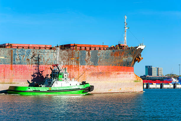 kleine schlepper unterstützung mehrerer cargo schiff in der litauischen harbor - piloting commercial dock harbor industrial ship stock-fotos und bilder