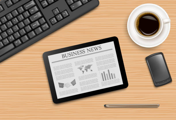 istock Tablet with news and office supplies laying on the board. 469193179