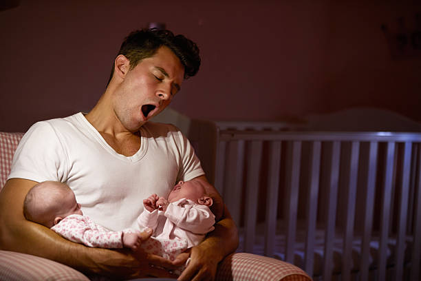 cansado pai com filha bebê em casa cuddling no berçário de solteiro - sibling baby three people baby girls - fotografias e filmes do acervo
