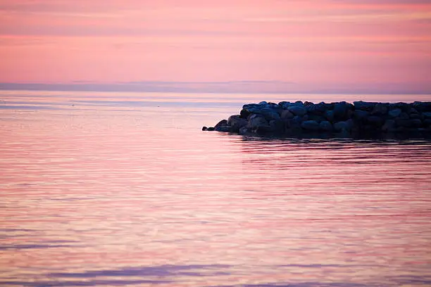 Sunset over the balticsea whit a stone pier in the foreground.GN