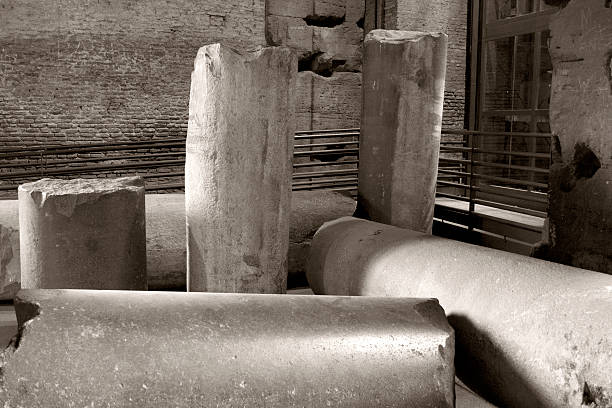 Sepia toned image. Architectural detail of the Roman Coliseum in Rome; Lazio; Italy. Pieces of ancient columns are in storage near the main entrance to the amphitheater. No people.