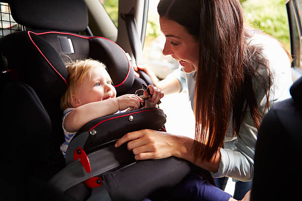 istock Mother securing infant daughter in car seat 469204592