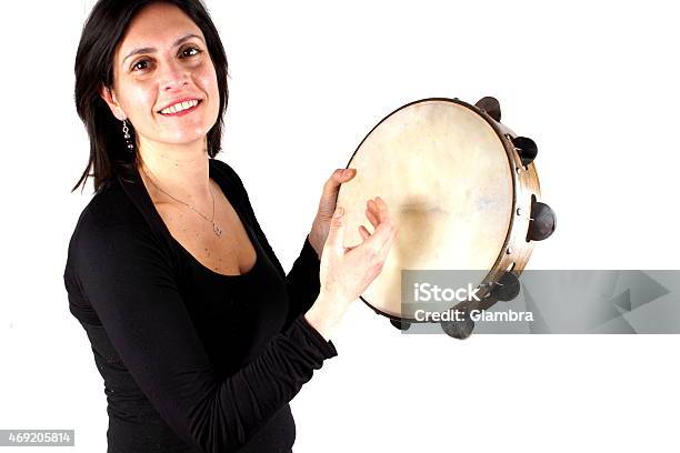 Portrait Of A Woman Playing A Tambourine Stock Photo - Download Image Now - 2015, Adult, Adults Only