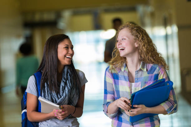 istock Pretty high school girl laughing with friend before class 469206240