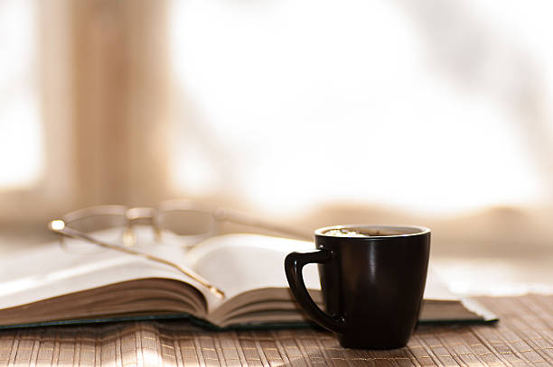 istock cup of coffee glasses rest on the open book 469211804