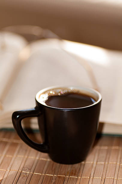 istock cup of coffee, standing next to an open book 469211806